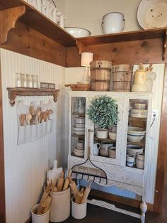 an old china cabinet with pots and pans on it