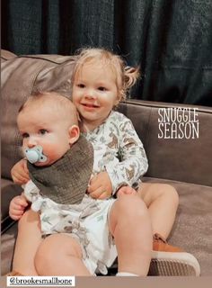 two babies are sitting on a couch with the caption snuggle season