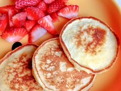 pancakes and strawberries on an orange plate