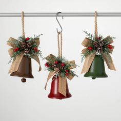 three christmas bells hanging from a metal bar