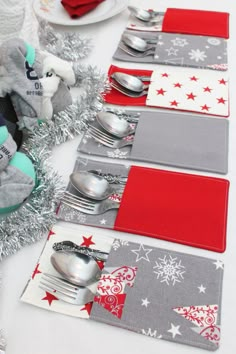 the table is set with silverware and red napkins on it, along with christmas decorations