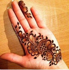 a woman's hand with henna tattoos on it