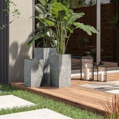 two cement planters sitting on top of a wooden deck next to a houseplant