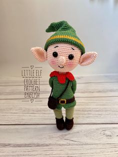 a small crocheted elf doll standing on top of a wooden table