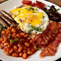 a white plate topped with eggs, beans and sausage