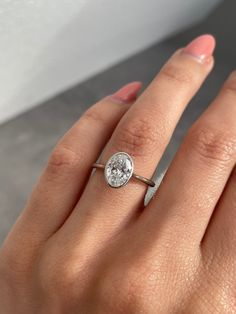 a woman's hand with a diamond ring on her finger and an engagement band