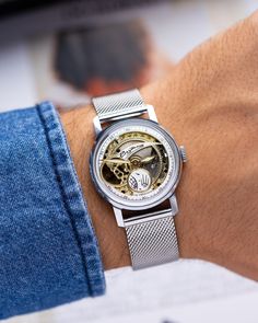 Experience the mesmerizing allure of the vintage Sputnik Skeleton watch - a captivating timepiece that unveils the intricate dance of mechanics and artistry. Unlike any other, this watch features a partial dial and exposed movement, allowing you to witness the inner workings with every glance. The delicate balance of the watch's mechanism mirrors the rhythmic beating of a heart, evoking a profound sense of connection and wonder. With each tick and tock, this timepiece creates a symphony of motion that resonates deep within. Encased in a versatile 35mm diameter, this watch effortlessly adorns any wrist, embodying timeless style and sophistication. At 6 o'clock, a unique circular second hand gracefully rotates, offering a mesmerizing display of time's passage. Movement: Mechanical cal.2602 C Watch Gift For Him, Watch Gift Box, Retro Watches, Watch Gift, Authentic Watches, Skeleton Watch, Wristwatch Men, Rare Antique, Buy Vintage