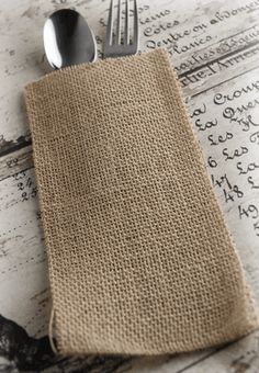 a fork, spoon and napkin sitting on top of a table