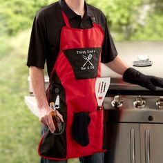 a man wearing an apron and cooking utensils in front of a bbq