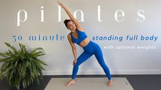 a woman in blue is standing on a yoga mat and stretching her arms with one hand