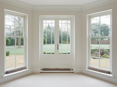 a room with three windows and a bench in it