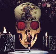 a man standing in front of a giant skull