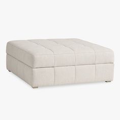 a white ottoman that is sitting on the ground