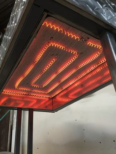 a close up of a light fixture with many lights on it's sides and some wires running down the ceiling