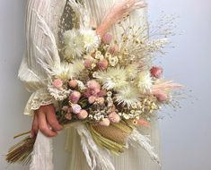 a woman holding a bouquet of flowers in her hands