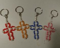 three key chains with beads in the shape of crosses