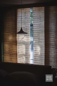 the light is shining through the blinds in the living room, and it looks like they have been made out of bamboo