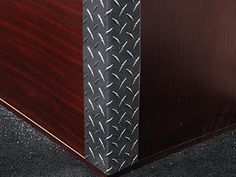 an office cubicle with black diamond plate on the front and dark cherry wood back