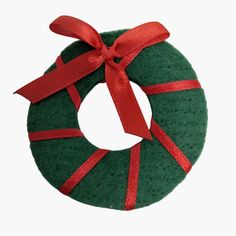 a green wreath with red ribbon on it