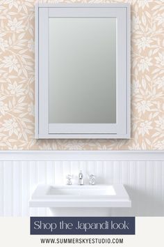 a white sink sitting under a bathroom mirror next to a wall mounted faucet