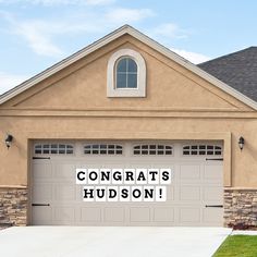 a house with a sign that says congrats hudson on the front and side