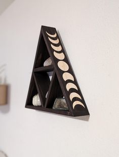 a triangle shaped shelf with rocks in it