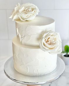 a three layer white cake with flowers on top