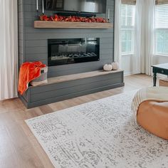 a living room filled with furniture and a flat screen tv mounted on the wall above a fire place