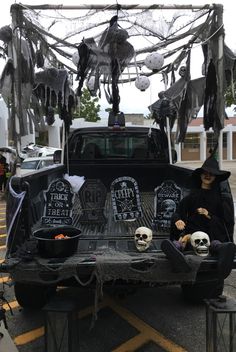 the truck is decorated with skeletons and skulls for halloween decorations, while two people sit in the bed