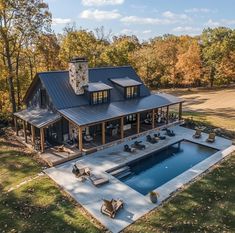 an aerial view of a house with a pool in the foreground and covered patio