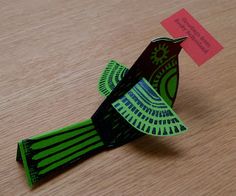 an origami bird sitting on top of a wooden table