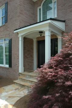 a brick house with white trim and black shutters