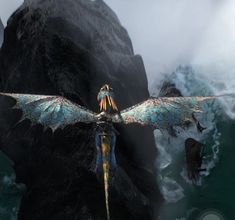 a large bird flying through the air next to a rocky mountain side in front of some water