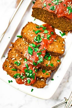 two slices of meatloaf on a plate with sauce and parmesan sprinkles