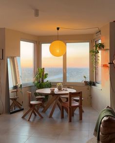 a living room with a table and chairs in front of large windows overlooking the city