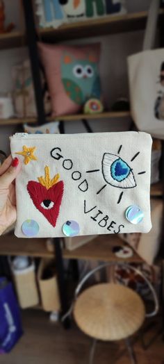 someone is holding up a bag with embroidered designs on it and the words good vibes