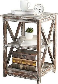 a small wooden shelf with books and a clock on it's top, next to a plant