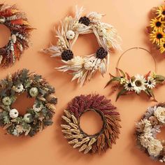 several wreaths are arranged on the wall with dried flowers and leaves around them,