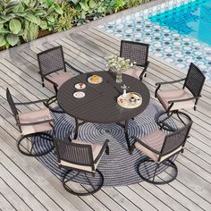 an outdoor table with chairs around it next to a swimming pool