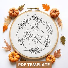 an embroidery pattern with leaves and acorns on it, surrounded by fall colors