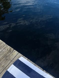 a blue and white towel sitting on the end of a dock