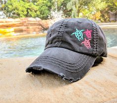 a black hat sitting on top of a rock next to a pool