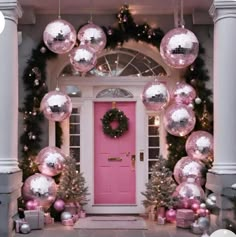 a pink door surrounded by christmas decorations