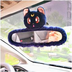 a car mirror with a black cat head hanging from it's side view mirror