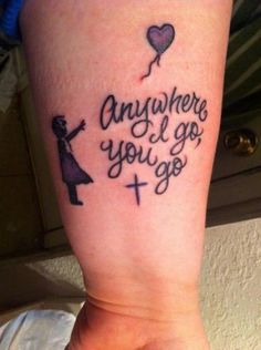 someone with a tattoo on their arm that says, anyone i go to the cross