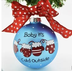 a baby's cold outside ornament hanging from a christmas tree with red bows