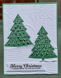 a christmas card with two green trees on the left and right side, in white paper