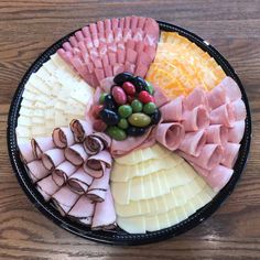 an assortment of meats and cheeses on a platter