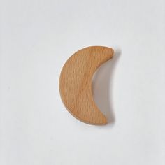 a wooden crescent shaped object on a white surface