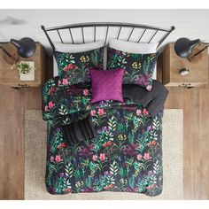 a bed with black and purple floral comforter